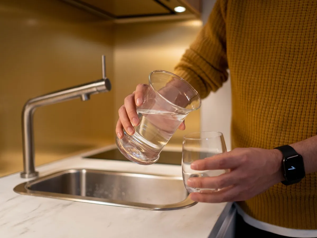 Instalação de filtros de água: copo a encher numa torneira de cozinha
